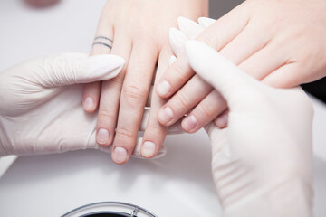 Close up of manicurist examining nails of client