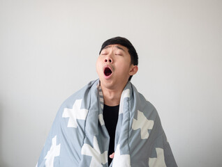 Man wake up with blanket cover his body and feel sleepy and yawn close the eye on white isolated