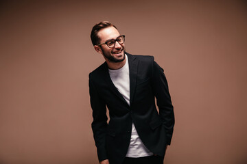 Stylish man in suit laughs on brown background