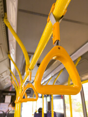 A large errand inside the bus. Half-empty public transport goes on its route. People go to work, on ground trangsport. There were more people on the buses.