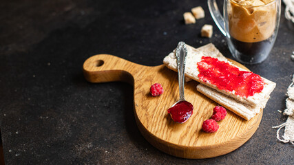 jam sandwich and cup of coffee berry jam, butter, organic whole grain diet bread crisp on the table, healthy food meal snack copy space food background rustic. top view