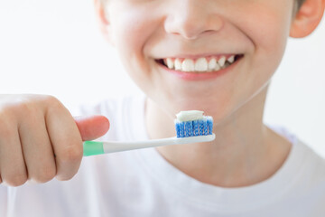 The boy is holding a toothbrush in his hands. Brushing your teeth. Soft focus