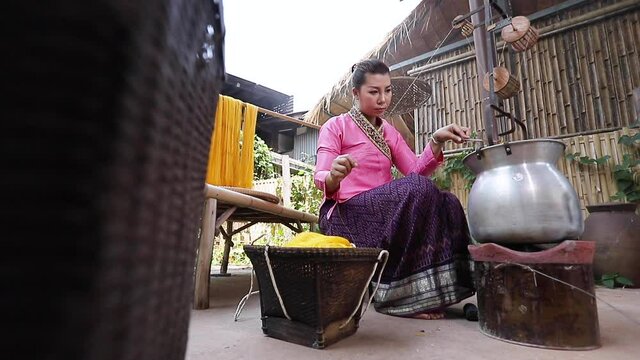 Crafts and craftsmanship. Boiling silk threads and making silk threads. Yarn warping machine in a textile weaving Craftsmanship. Nongkhai, Thailand.