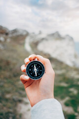 Woman hiker with a compass in her hands and a beautiful manicure in the background walking trail. - obrazy, fototapety, plakaty