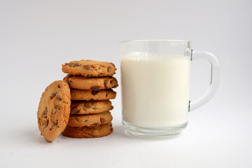 Stack of chips chocolate cookies and glass of milk isolated on white background. Healthy snack.