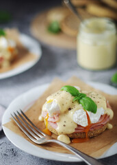 Egg benedict sandwiches - muffin with poached egg, ham and hollandaise sauce