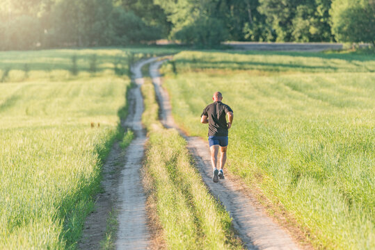 Athletic man covers long distance at sunset time.