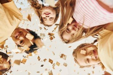 View from below. Children on celebrating birthday party indoors have fun together