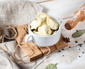 False mastic dumplings with sweet chocolate filling in a white glass and a wooden board.