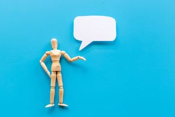 Wooden man figure presenting and showing on speech bubble banner