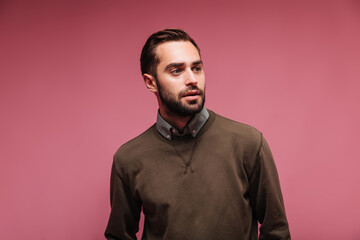 Portrait of man in brown sweater on pink background
