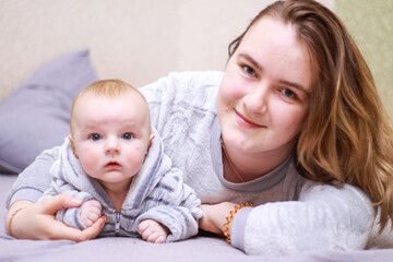 home photos of a young mother with a small child. Newborn boy. Cute, cozy photos with a baby.