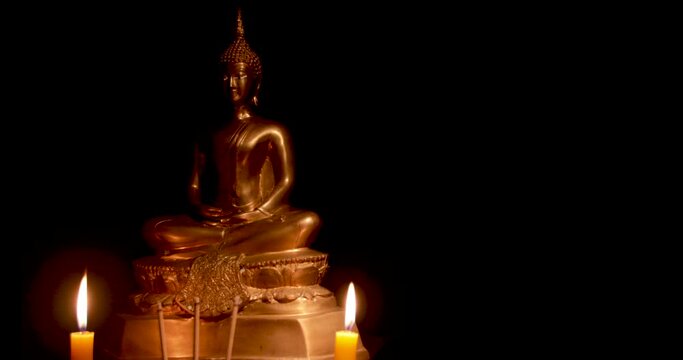 Stop motion photo,Burning incense and candles to pay homage to the Buddha image , black background,floating incense smoke
