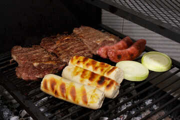 Barbecue of rump steak, garlic bread with gratin cheese, sausage, onion rings. Barbecue on the Parrilla.