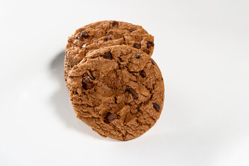 Plate of freshly baked chocolate chip cookies from top view. Wooden background, selective focus