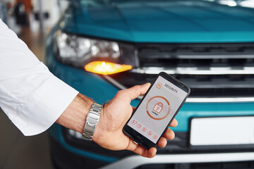 Close up view of man's hand that holds phone with labels and icons. Conception of remote control