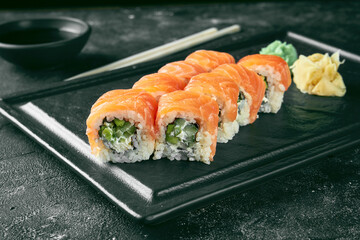 Uramaki sushi Philadelphia with salmon, cucumber and avocado. Classic Japanese cuisine. Food delivery.