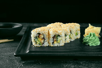 Uramaki sushi california roll in sesame with eel, avocado and cucumber. Classic Japanese cuisine. Food delivery.