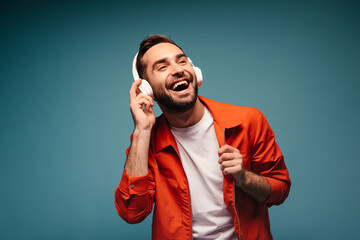 Naklejka premium Active man in orange outfit laugh and listens music