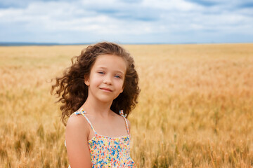 Fototapeta na wymiar A young girl walking in a wheat field
