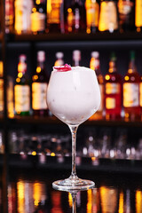 Beautiful white cocktail in an elegant glass on a bar counter in a nightclub, close-up. Space for text. High quality photo