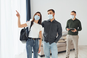 Man helps the young couple in choosing an apartment