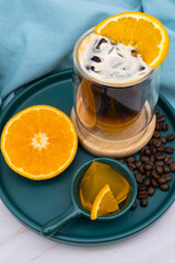 Iced americano black coffee and a layer of orange juice.