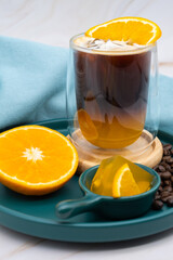 Iced americano black coffee and a layer of orange juice.