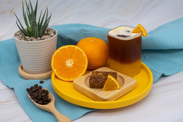 Iced americano black coffee and a layer of orange juice.