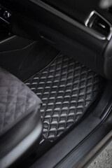 Car floor mat with diamond pattern. Ecoleather dark floormat on the second row in the modern...