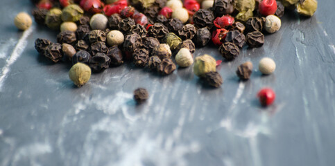 Mix of peppers peas on a dark background, close-up with blur foreground, copy space