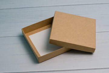 Empty gift box on a light wooden table. The concept of a gift for the holiday, what to give.