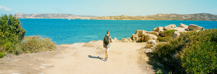 man walks next to the sea in Sardinia, web banner