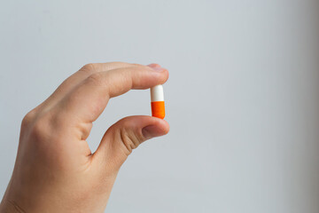Hand hold big capsule pill of the azithromycin antibiotic, bacterial infection treatment