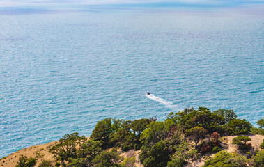 Anapa, Russia - June 11, 2021: Stony beach of Black Sea coast in Bolshoy Utrish village full of people on bright sunny summer day. Aerial view.
