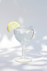 a glass of refreshing cold water with a slice of lemon in summer
