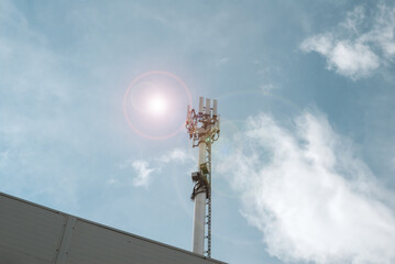 Cell tower. Tower of the fifth generation network. Sun at noon on a clear sky
