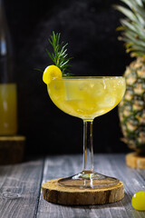 Yellow cocktail on the table with ice and pineapple 