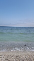 Pebbles, sunlight and ripple patterns on the sea