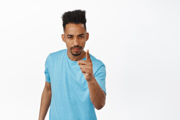 Very bad behaviour. Disappointed african american young man scolding person, shaking finger, furrow...