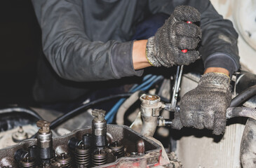 The mechanic is checking the engine.