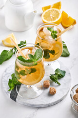 Traditional iced tea with lemon and ice in tall glasses on marble table background Iced tea with lemon. Selective focus. Refreshment cold summer drink.