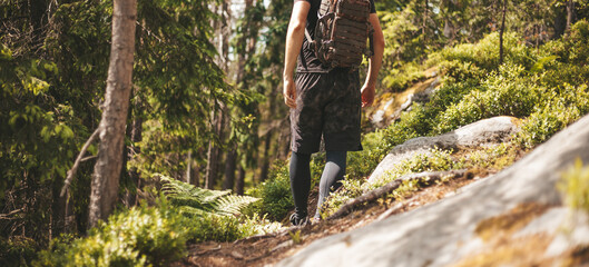 Travel or hike through the woods with a backpack. A man walks along the trail, active rest.