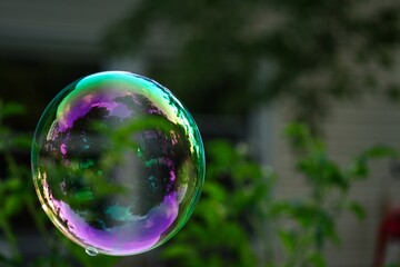 Close up of single bubble floating in garden, selective focus