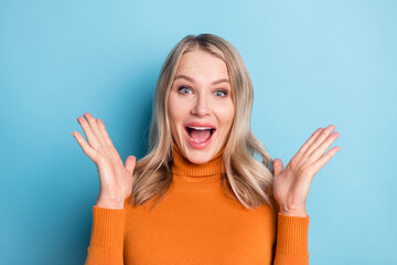 Photo of young amazed shocked happy woman raise palms news discount isolated on blue color background