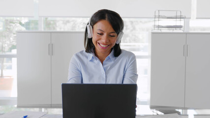 Portrait of happy smiling black designer woman with headphones working at office