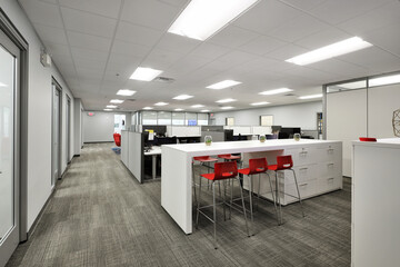Interior of modern office business building hallway with red chairs and white desks