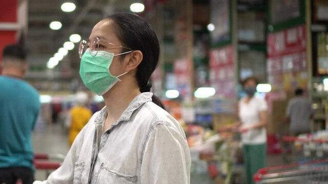 Asian woman wearing mask queue in hypermarket social distance