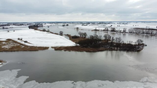 High water level on the snowy floodplains of the river IJssel near the city of Zwolle in Overijssel, The Netherlands. Aerial drone point of view.