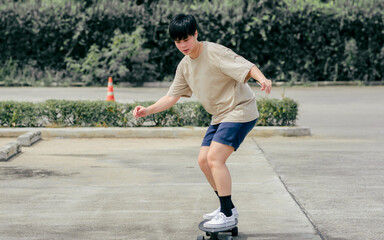 Portrait adult sportive Asian skater wearing hipster shirt with shorts, smiling with happiness,...